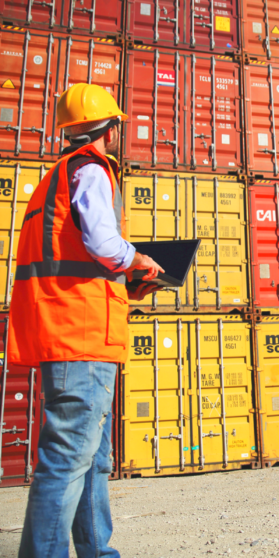 Employee in safety jacket controlling containers