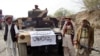 FILE - Armed militants of Tehrik-e-Taliban Pakistan (TTP) are pictured next to a captured armored vehicle in the Pakistan-Afghanistan border town of Landikotal on Nov. 10, 2008, after they hijacked supply trucks bound for Afghanistan.