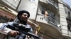 A Taliban fighter stands guard at the site where an explosives-laden vehicle detonated amid an attack on a Sikh temple in Kabul, Afghanistan, June 18, 2022.