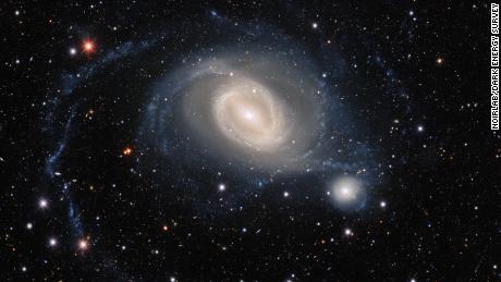 The interacting galaxy pair NGC 1512 and NGC 1510 take center stage in this image from the Dark Energy Camera, a state-of-the art wide-field imager on the Víctor M. Blanco 4-meter Telescope at Cerro Tololo Inter-American Observatory, a Program of NSF&#39;s NOIRLab. NGC 1512 has been in the process of merging with its smaller galactic neighbor for 400 million years, and this drawn-out interaction has ignited waves of star formation and warped both galaxies.