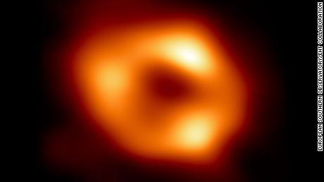 This is the first image of Sgr A*, the supermassive black hole at the centre of our galaxy, with an added black background to fit wider screens. It&#39;s the first direct visual evidence of the presence of this black hole. It was captured by the Event Horizon Telescope (EHT), an array which linked together eight existing radio observatories across the planet to form a single &quot;Earth-sized&quot; virtual telescope. The telescope is named after the event horizon, the boundary of the black hole beyond which no light can escape.   Although we cannot see the event horizon itself, because it cannot emit light, glowing gas orbiting around the black hole reveals a telltale signature: a dark central region (called a shadow) surrounded by a bright ring-like structure. The new view captures light bent by the powerful gravity of the black hole, which is four million times more massive than our Sun. The image of the Sgr A* black hole is an average of the different images the EHT Collaboration has extracted from its 2017 observations.  In addition to other facilities, the EHT network of radio observatories that made this image possible includes the Atacama Large Millimeter/submillimeter Array (ALMA) and the Atacama Pathfinder EXperiment (APEX) in the Atacama Desert in Chile, co-owned and co-operated by ESO is a partner on behalf of its member states in Europe.