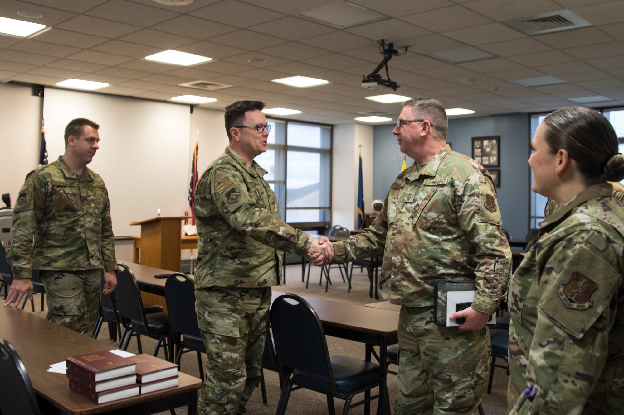 Military members shake hands before church service