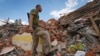 A Ukrainian serviceman looks at the rubble of a school that was destroyed some days ago during a missile strike in outskirts of Kharkiv, Ukraine, July, 5, 2022.