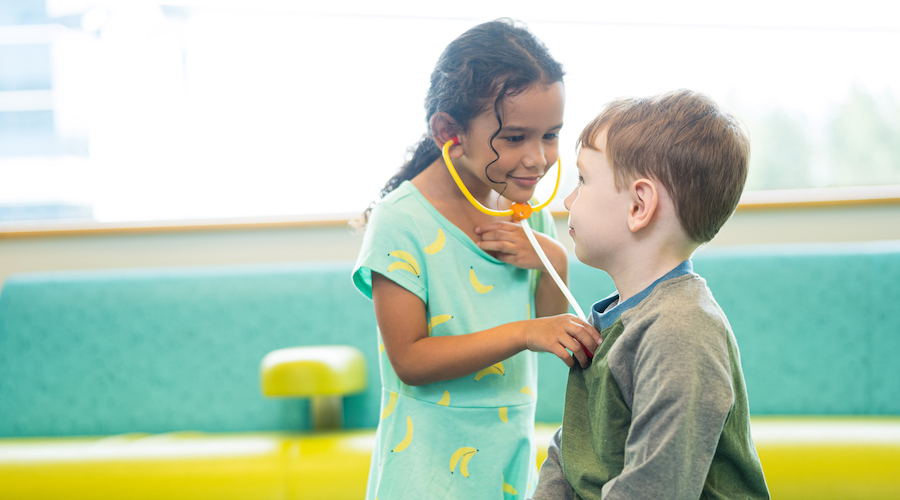 Photo of two children playing with a toy stethoscope