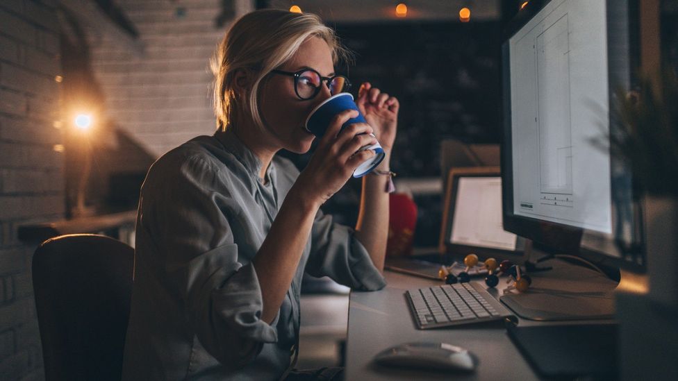 Woman drinking coffee as she works