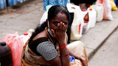 A woman waits in a queue to buy kerosene while sitting on a pavement, amid the country"s economic crisis, in Colombo, Sri Lanka June 17, 2022