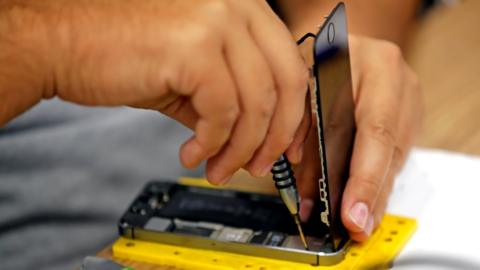 Hands fixing a phone