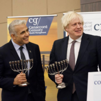 Foreign Minister Yair Lapid (L) and British Prime Minister Boris Johnson at a Conservative Friends of Israel event in London, Britain, November 29, 2021. (Stuart Mitchell)