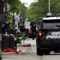 US law enforcement search in downtown Highland Park, a Chicago suburb, after a mass shooting at the Highland Park Fourth of July parade, July 4, 2022. (AP Photo/Nam Y. Huh)