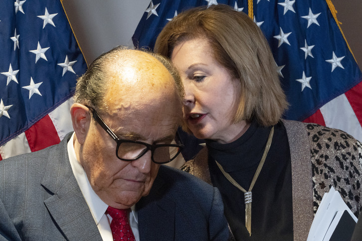 Trump lawyer Sidney Powell speaks into Rudy Giuliani's ear.