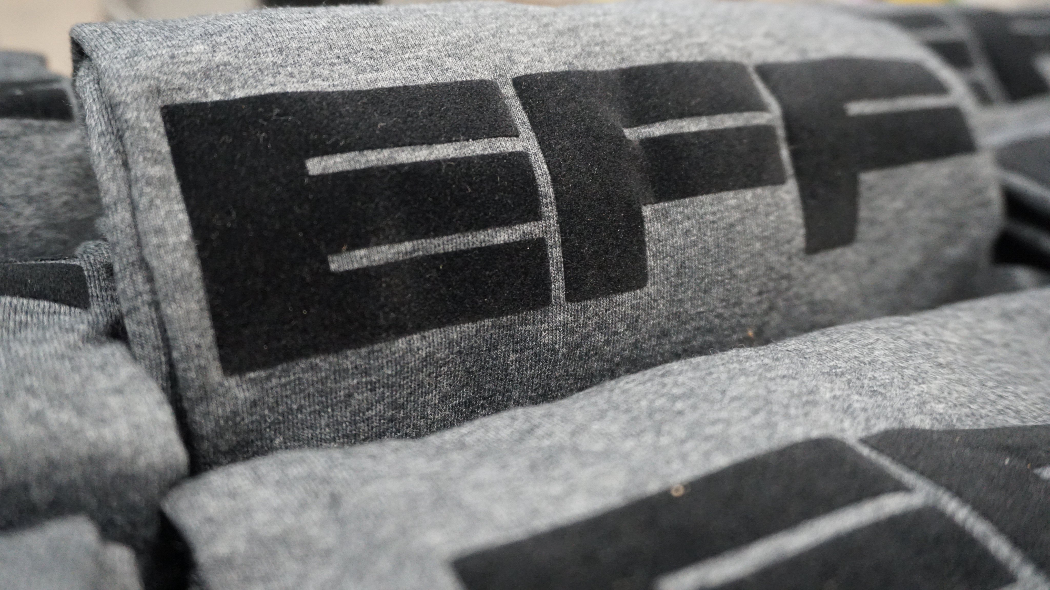 EFF's new Fuzzy Monogram t-shirt. A grey heather shirt with black EFF logo on the front.