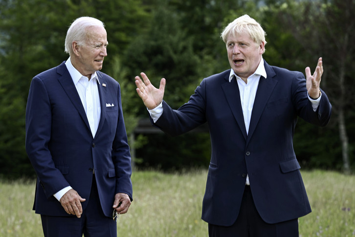 US President Joe Biden, left, and Britain's Prime Minister Boris Johnson, right, chat as they gather for a group photo.