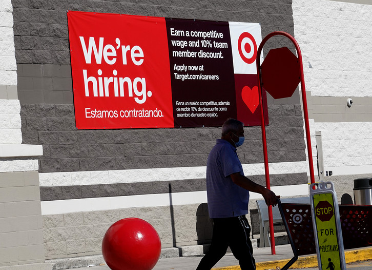 A &quot;we're hiring&quot; sign hangs on the wall of a Target store.