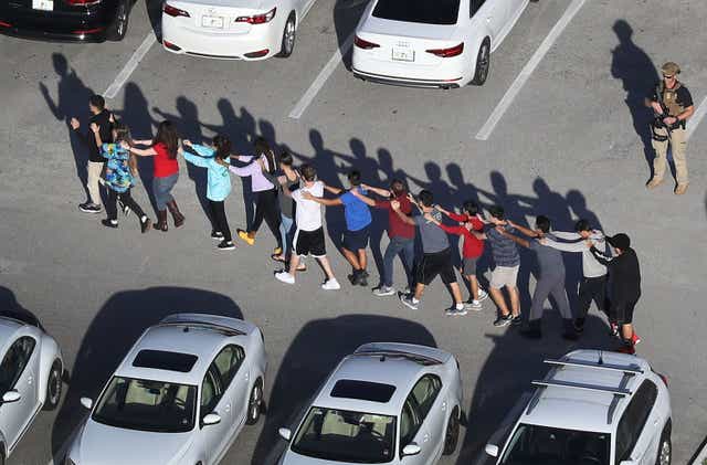 <p>Students are led out of Marjory Stoneman Douglas High School following the mass shooting </p>