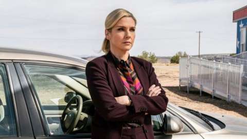 woman leaning against car