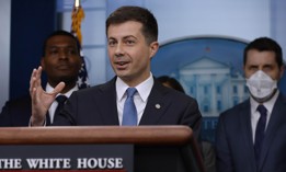 Transportation Secretary Pete Buttigieg (C) speaks during a news conference marking six months since the signing of the bipartisan infrastructure bill at the White House in May.