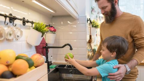 Little boy washing fruits and vegetables