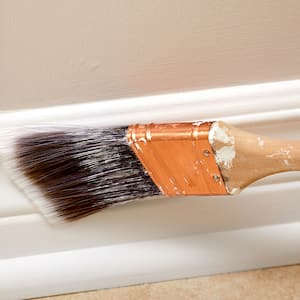 A view of white baseboard being painted