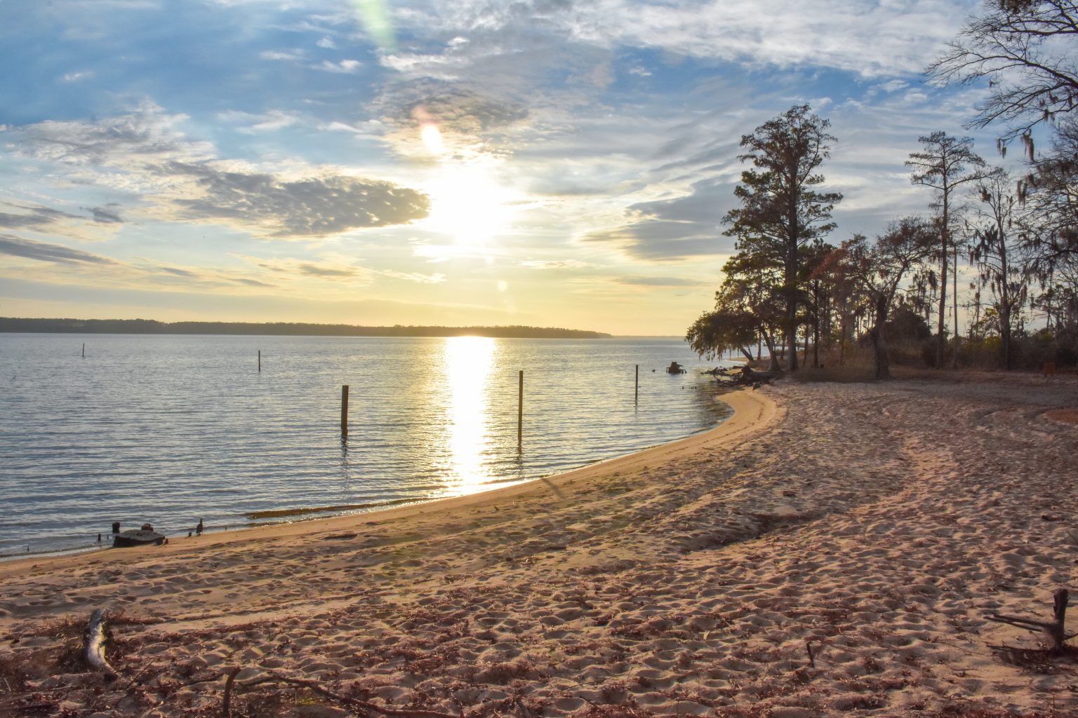 Sunset with yellow and blue hues over the Pamlico River in North Carolina (US). The water reflects the setting sun. Photo by Marcus Burnette on the WordPress Photo Directory.