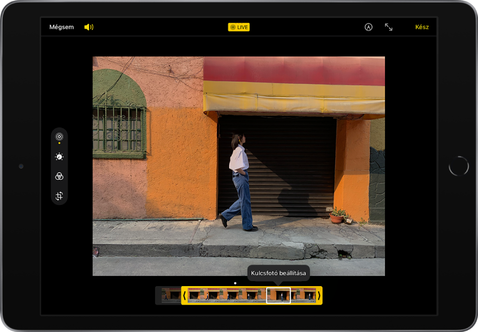 A Szerkesztés képernyő közepén egy Live Photo látható, A Live Photo képkocka-nézegető a képernyő alján látható. A Mégsem és a Hangerő gomb a bal felső sarokban látható, a Live Photo gomb a felső rész közepén látható, illetve a Korrektúra, a Belépés teljes képernyős módba és a Kész gomb a jobb felső sarokban látható. A szerkesztési eszközök a képernyő bal oldalán jelennek meg a következő sorrendben (fentről lefelé): Live Photo, Beállítás, Szűrők és Körbevágás. A Live Photo van kiválasztva.