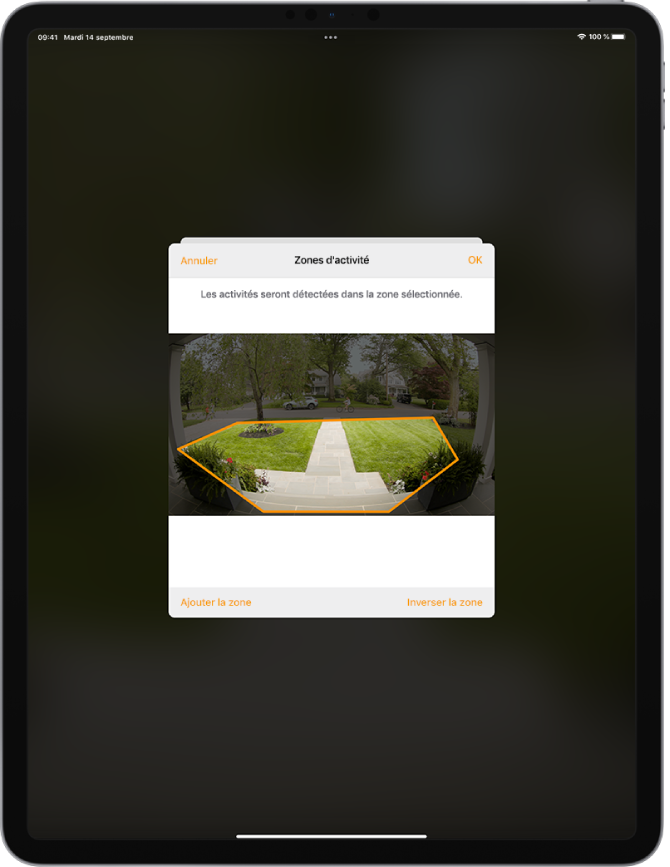 Écran d’iPad montrant une zone d’activité dans une image prise par une caméra de porte. La zone d’activité inclut un perron et une allée, mais exclut la rue et la voie d’accès. Les boutons Annuler et OK se trouvent au-dessus de l’image. Les boutons « Ajouter la zone » et « Inverser la zone » se trouvent en dessous.