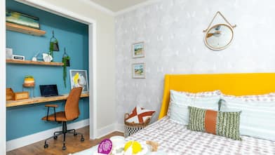 A bedroom with office space and modern bright colors