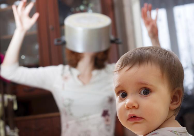 Surprised baby looking away from absurd mother.