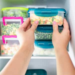 Woman taking frozen food out of freezer