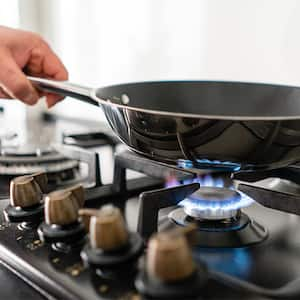 Man using frying pan on gas range