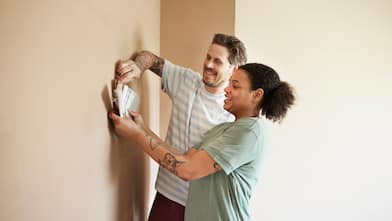 A young couple choosing paint color for their home