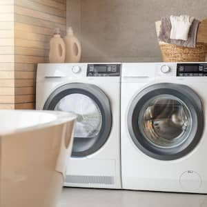 A laundry room with two white appliances