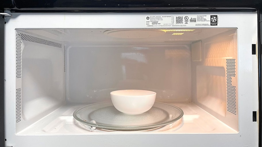 A white bowl sits inside a microwave