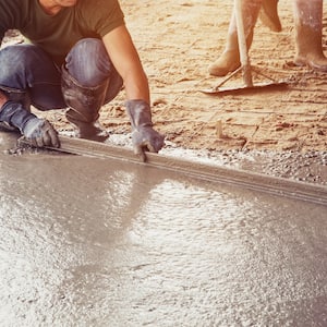 Man spreading concrete for a floor