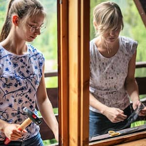 Mother and daughter repairing window screen