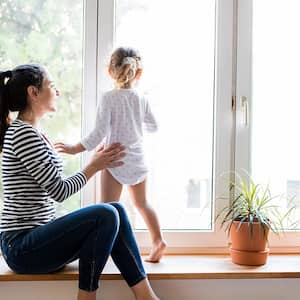 woman and child sitting near window  