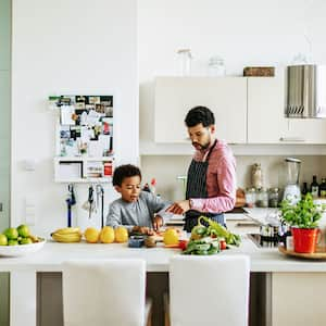 Son helping father cooking a meal