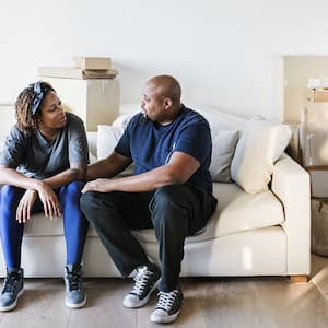 Couple sitting on couch, moving into new house