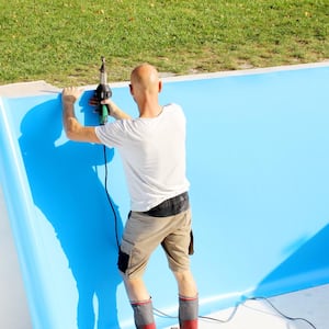 A man replacing a pool liner