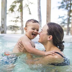 Boy playing with his mother in hot tub