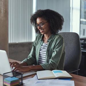 A listing agent checking property prices on laptop