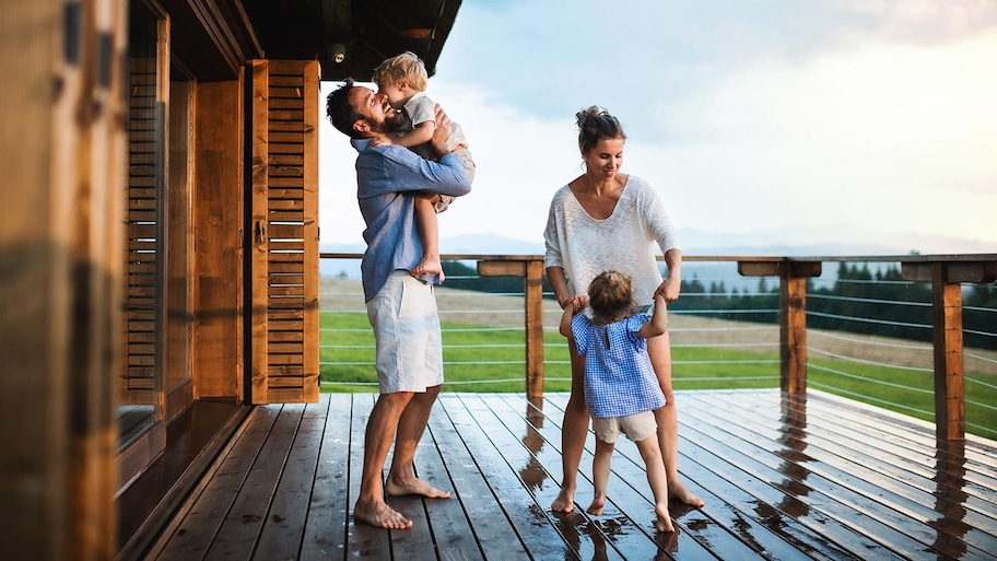 Family plays in rain on wood deck