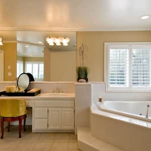 A large bathroom with a vanity and the lights attached to the mirror