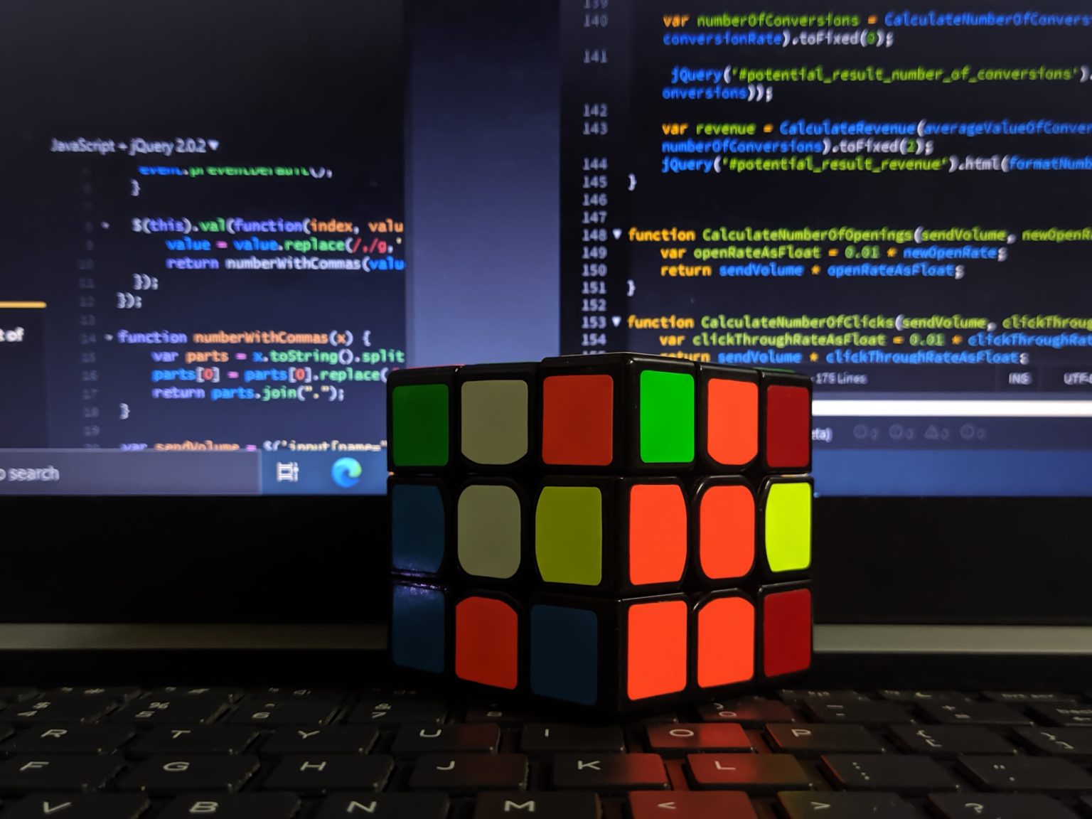 Close-up of a Rubik's cube on a keyboard, with code in the background. Photo contributed by Tahmid ul Karim to the WordPress Photo Directory.