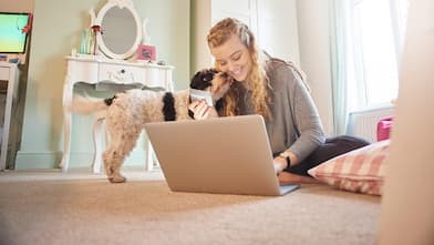 Girl on floor with laptop and dog