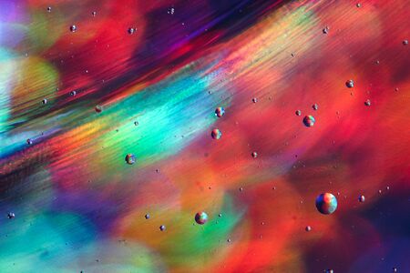 Photography Liquid Surface with Holographic Bokeh Effect of Orange, Blue, Red Colors. Top View of Bright Abstract Texture Oil Bubbles in Water.