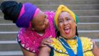 Woman laughing in yellow traditional African clothes