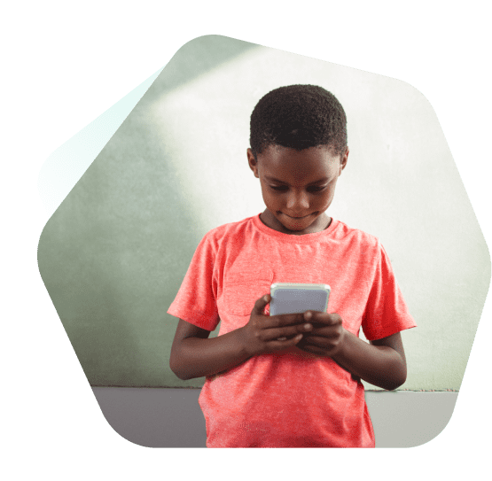 Young boy watching videos on a mobile phone outside