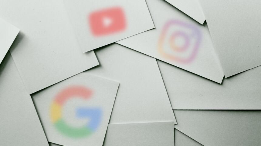 Logos von Google, YouTube und Instagram verschwommen auf Blättern, die auf einer Fläche verteilt sind