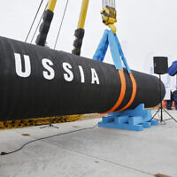 A Russian construction worker speaks on a mobile phone during a ceremony marking the start of Nord Stream pipeline construction in Portovaya Bay some 170 kms (106 miles) north-west from St. Petersburg, Russia on April 9, 2010. (AP Photo/Dmitry Lovetsky)