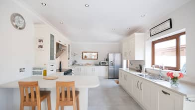 A spacious and bright kitchen with white cabinets